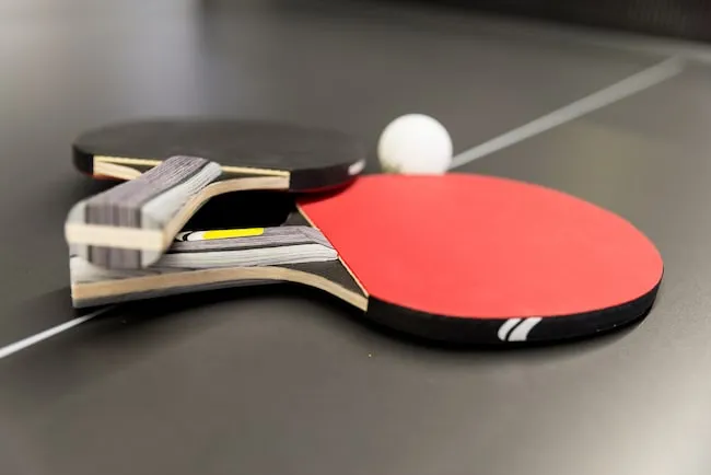 Ping pong rackets and ball on black table tennis
